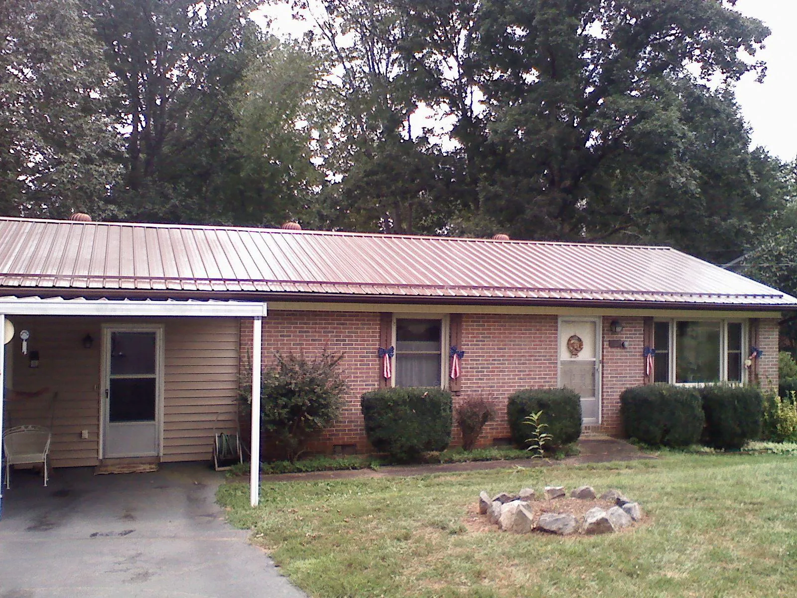 Bronze metal roof and carport on a brick ranch home — Roof Repair work by our crew in Climax